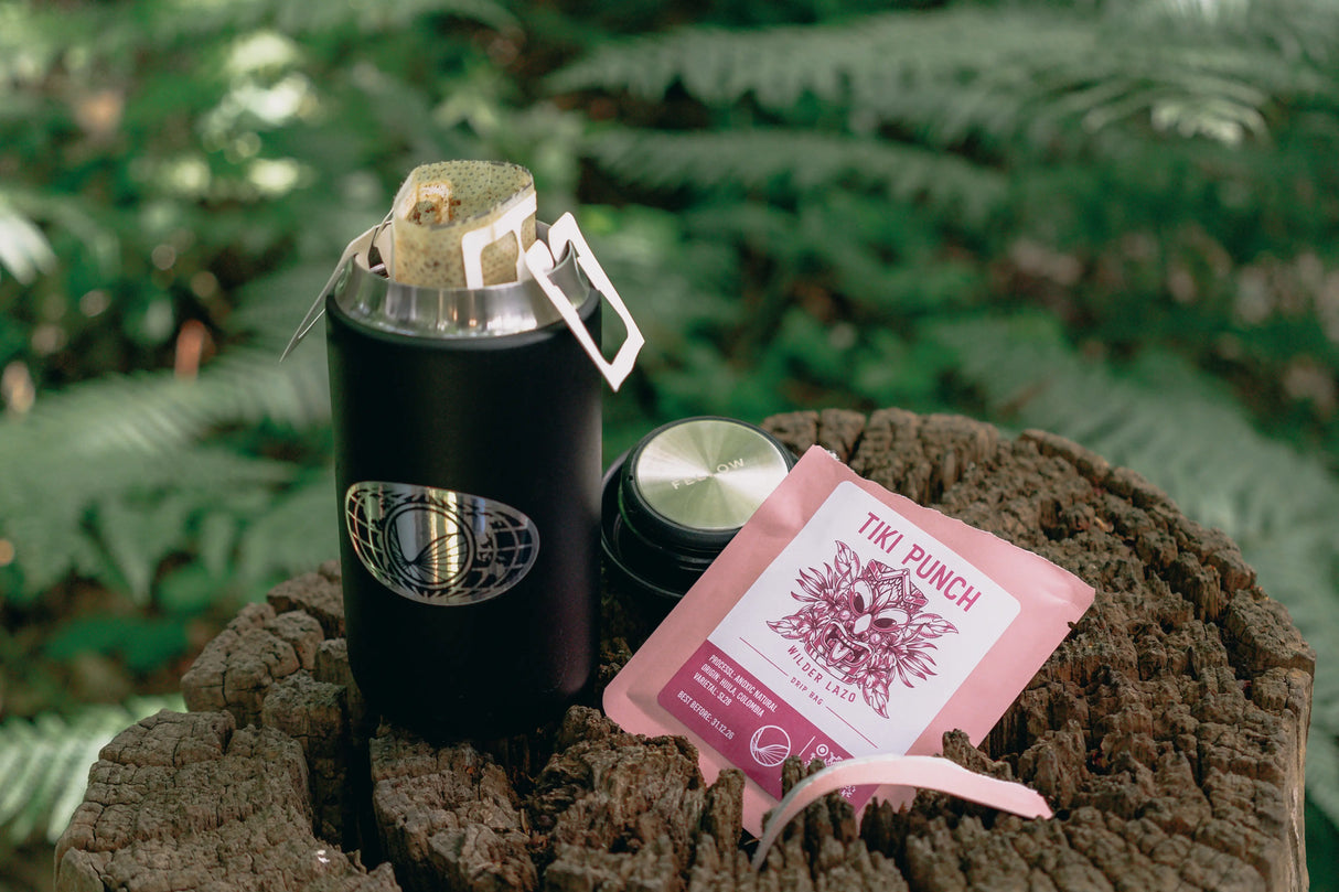 Coffee drip bag containing Wilder Lazo Tiki Punch, Colombia, being brewed in a forest