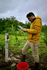 Akshay Dashrath, restless innovator at Mooleh Manay Estate, checking data from environmental sensors amongst the coffee trees.