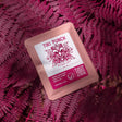 Coffee drip bag containing Wilder Lazo Tiki Punch, Colombia, on a pink background