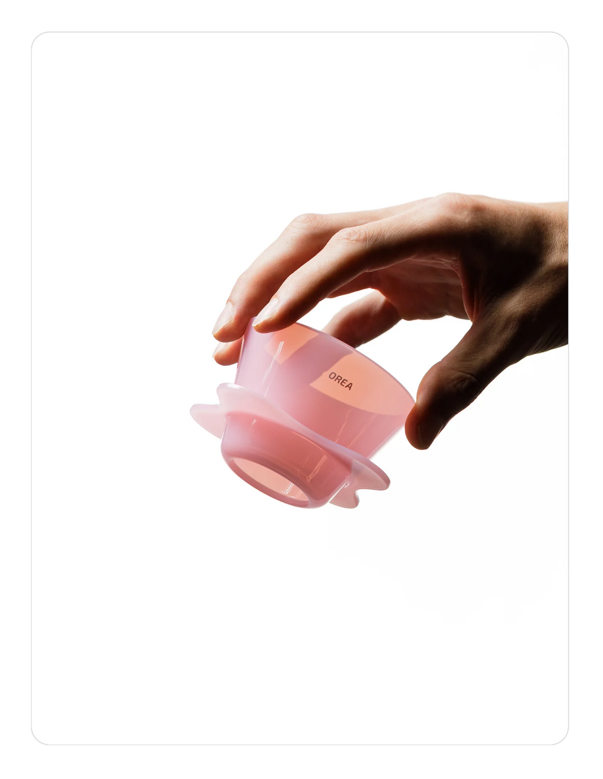Hand holding a Creamy pink OREA 01 brewer on a white background