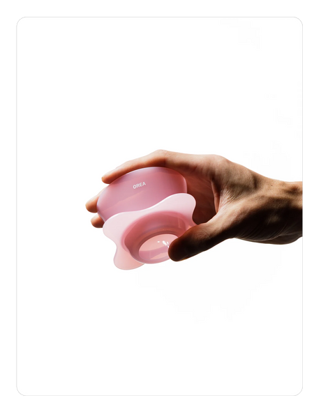 Hand holding a Creamy pink OREA 01 brewer on a white background
